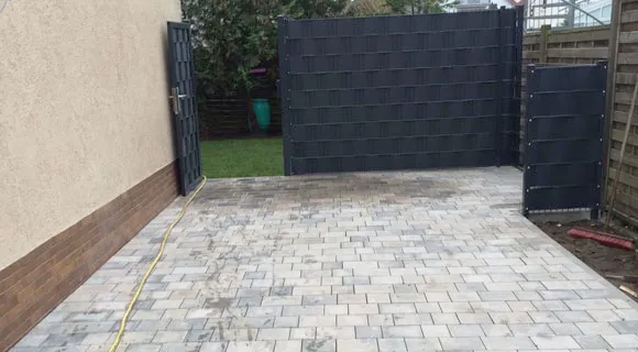 grau gepflasterter Eingangsbereich mit Gartentor
