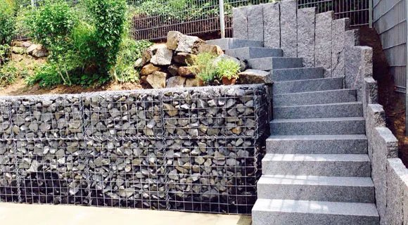 grau gepflasterter Treppenaufgang mit Natursteinmauer