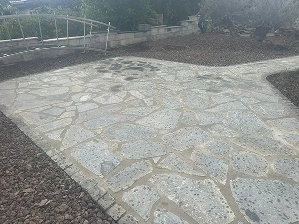 grau verlegte Natursteine in frisch angelegtem, unbepflanztem Beet