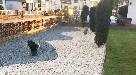 bepflanztes Kiesbeet mit Gartenstrahler